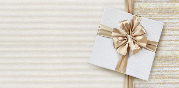 Coffret cadeau élégant au ruban doré sur tissu crème, idée de cadeau soin naturel CAMENYS
