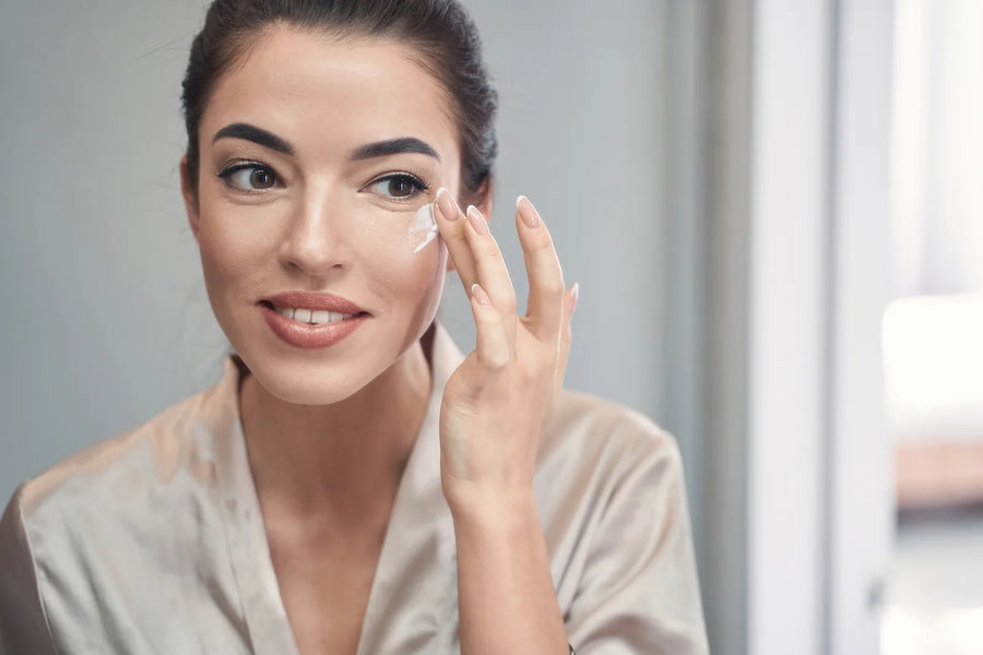 Femme appliquant une crème de nuit apaisante sur peau sensible, lumière naturelle chaude