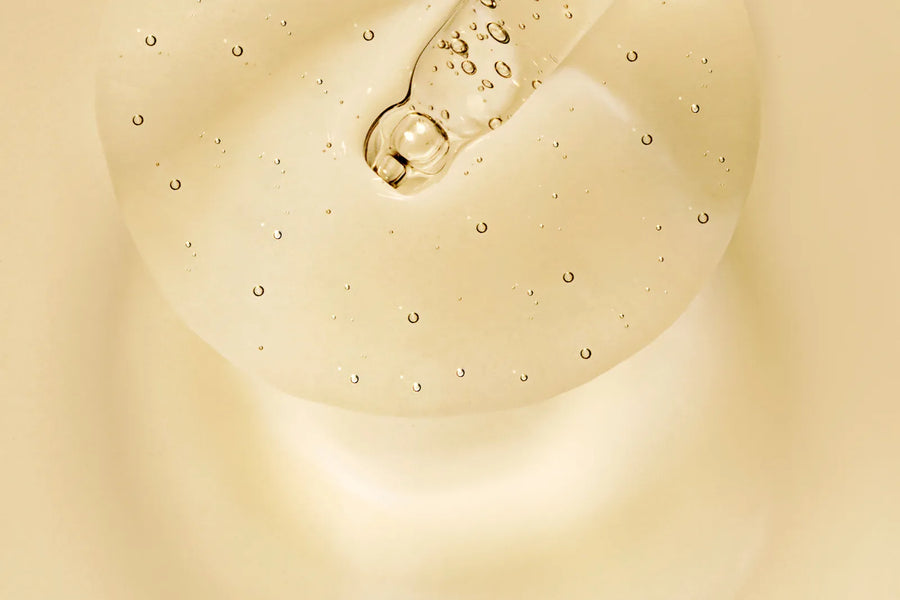 Texture de sérum peptides beige translucide avec pipette en gros plan — CAMENYS