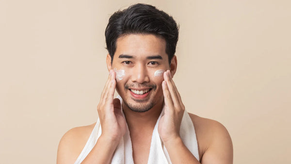 Homme appliquant un soin visage naturel à la main, routine skincare masculine