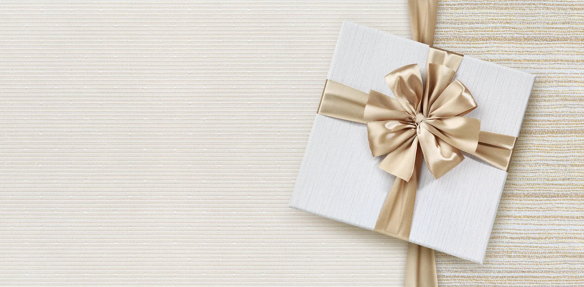 Coffret cadeau élégant au ruban doré sur tissu crème, idée de cadeau soin naturel CAMENYS