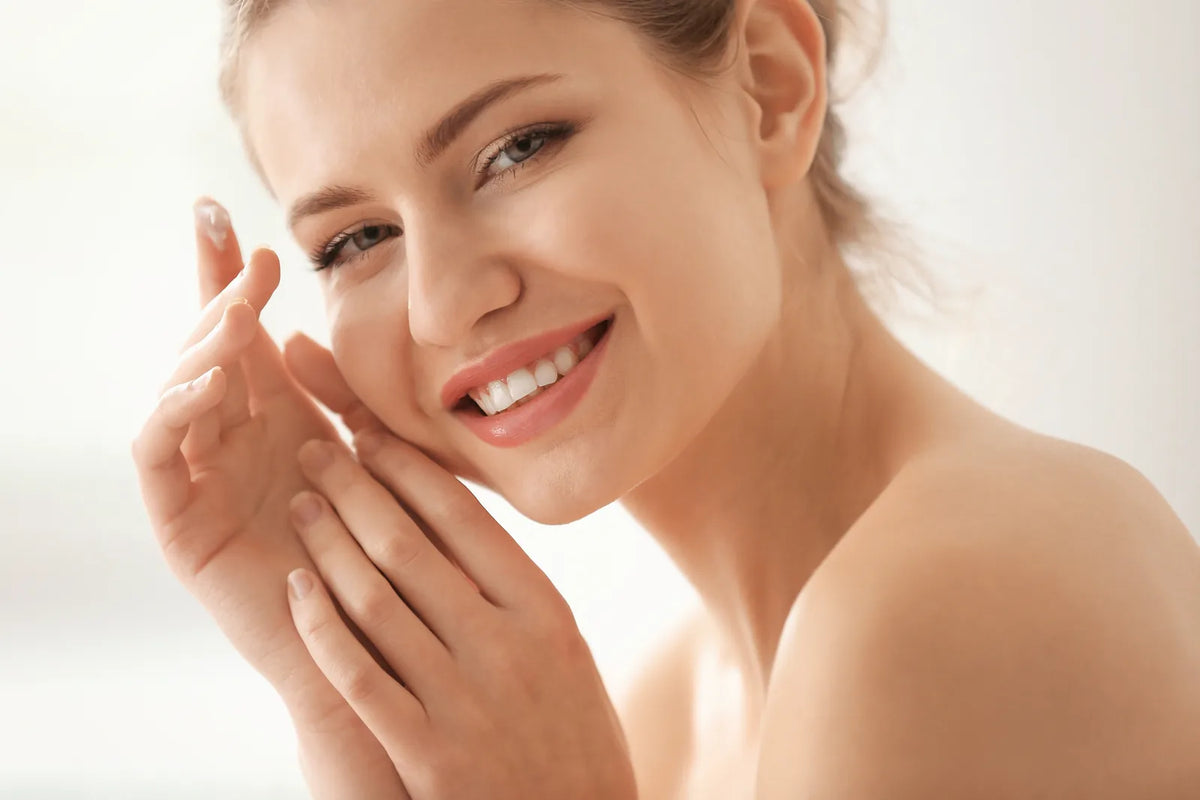 Femme appliquant délicatement une crème sur sa peau sensible, lumière naturelle douce