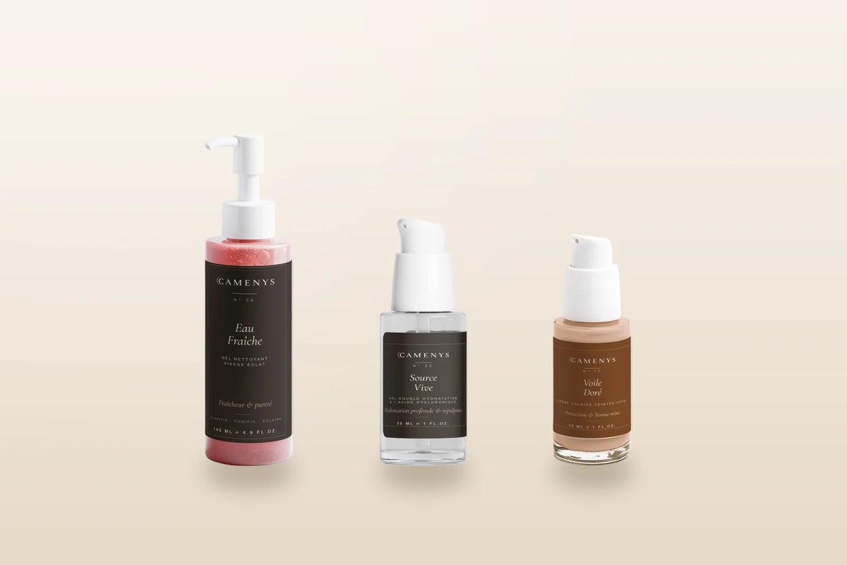 Trois soins CAMENYS d'une routine minimaliste — nettoyant, gel hydratant et crème solaire teintée — sur fond crème lumineux